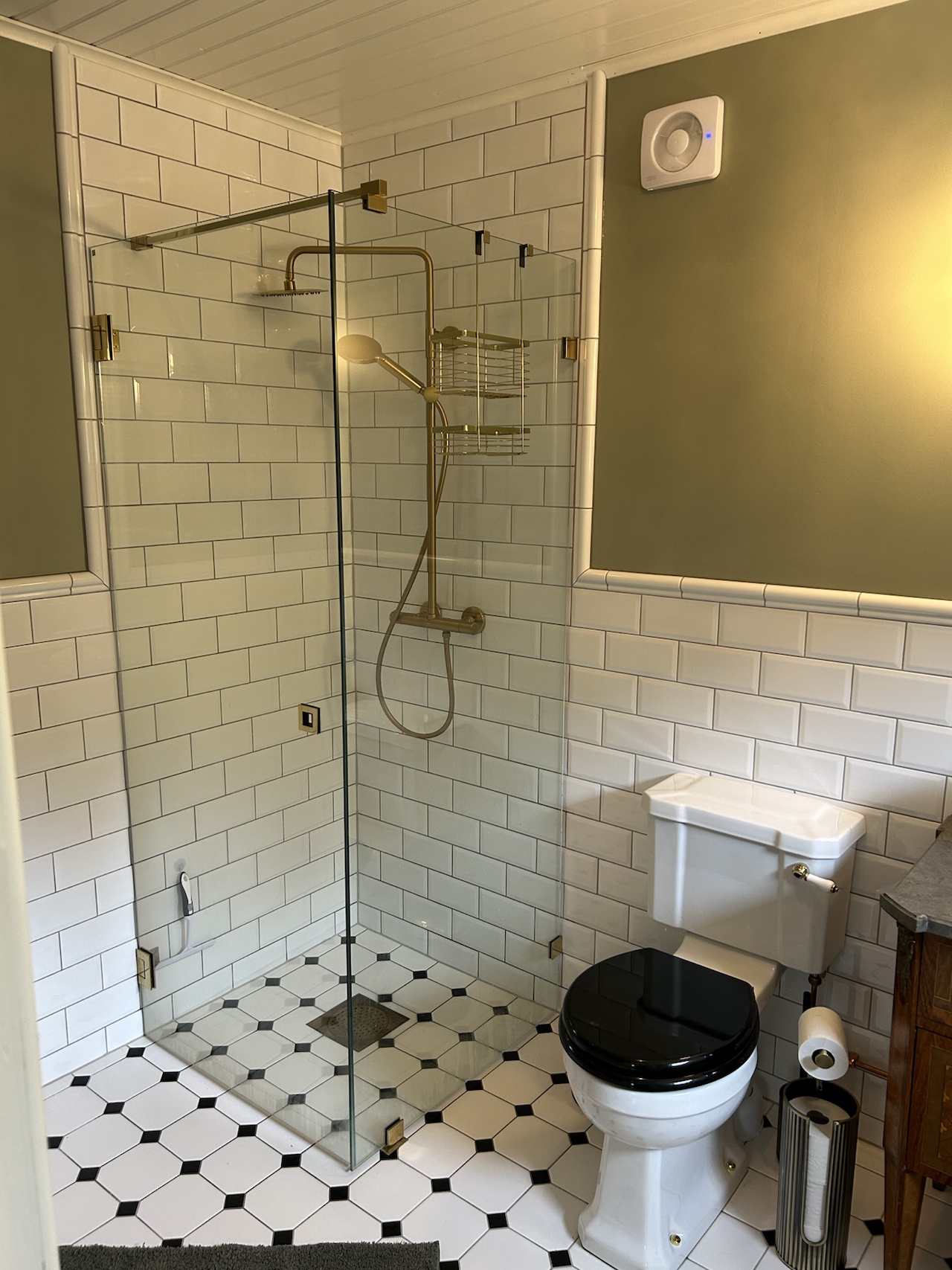 Tiled bathroom with a glass shower screen and white subway tiles