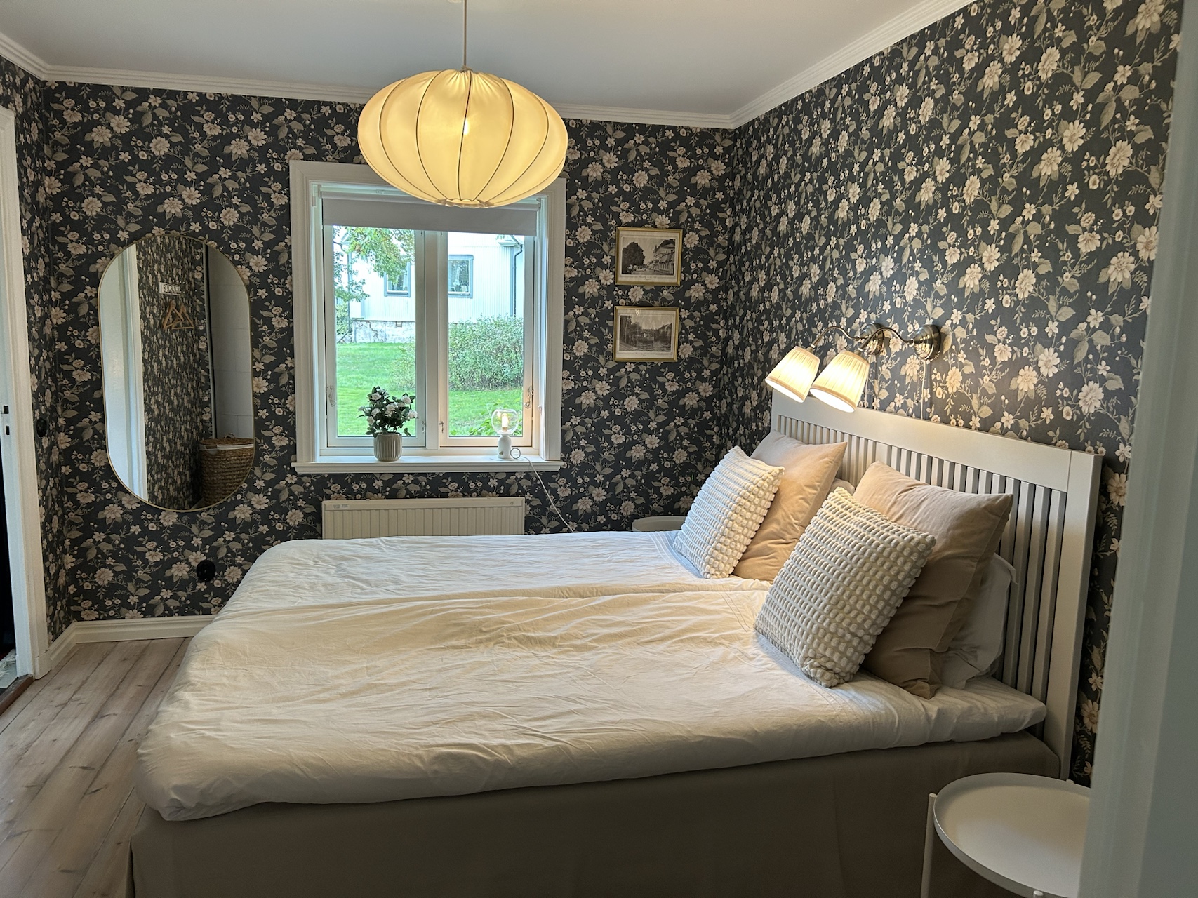 Double bed in a patterned bedroom with a window and bedside tables