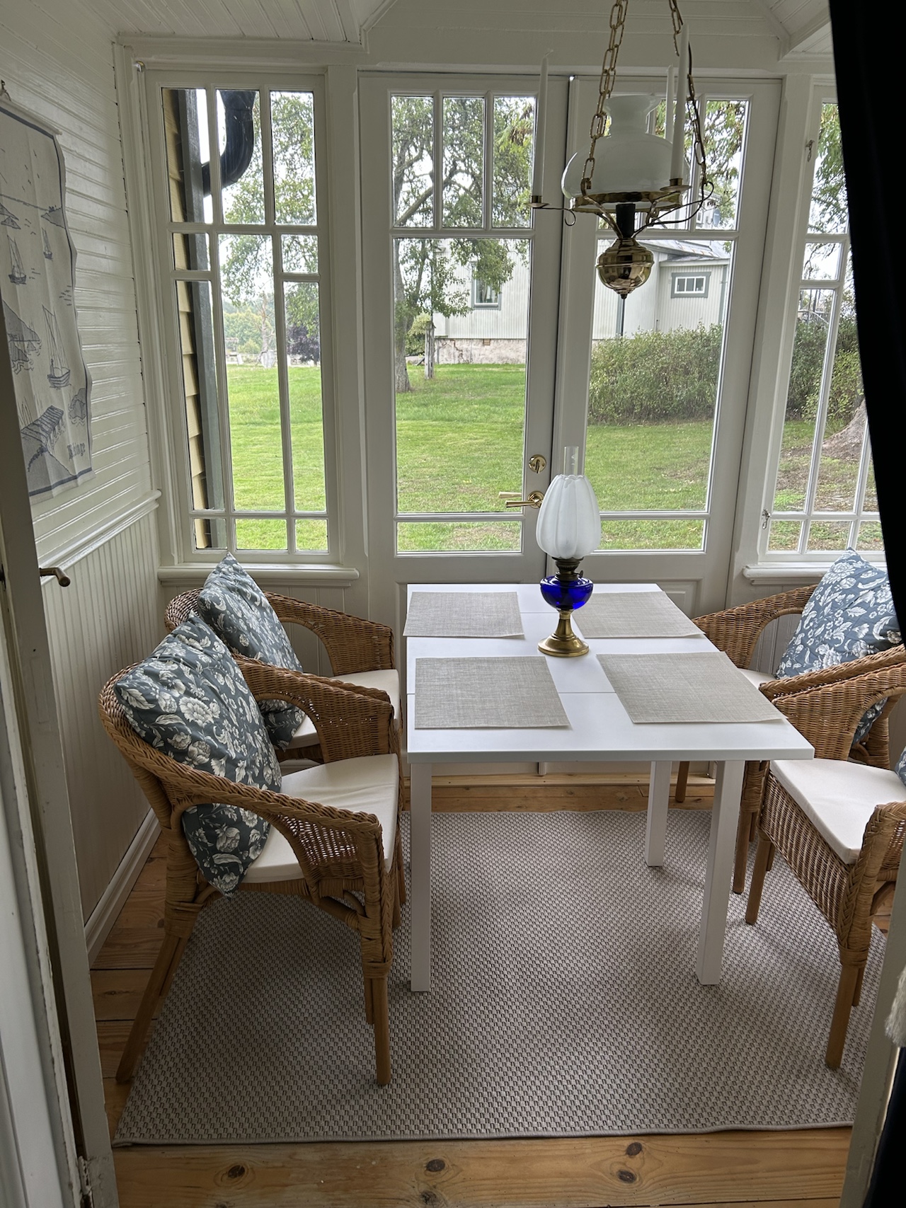Enclosed glass veranda furnished with a small table and chairs