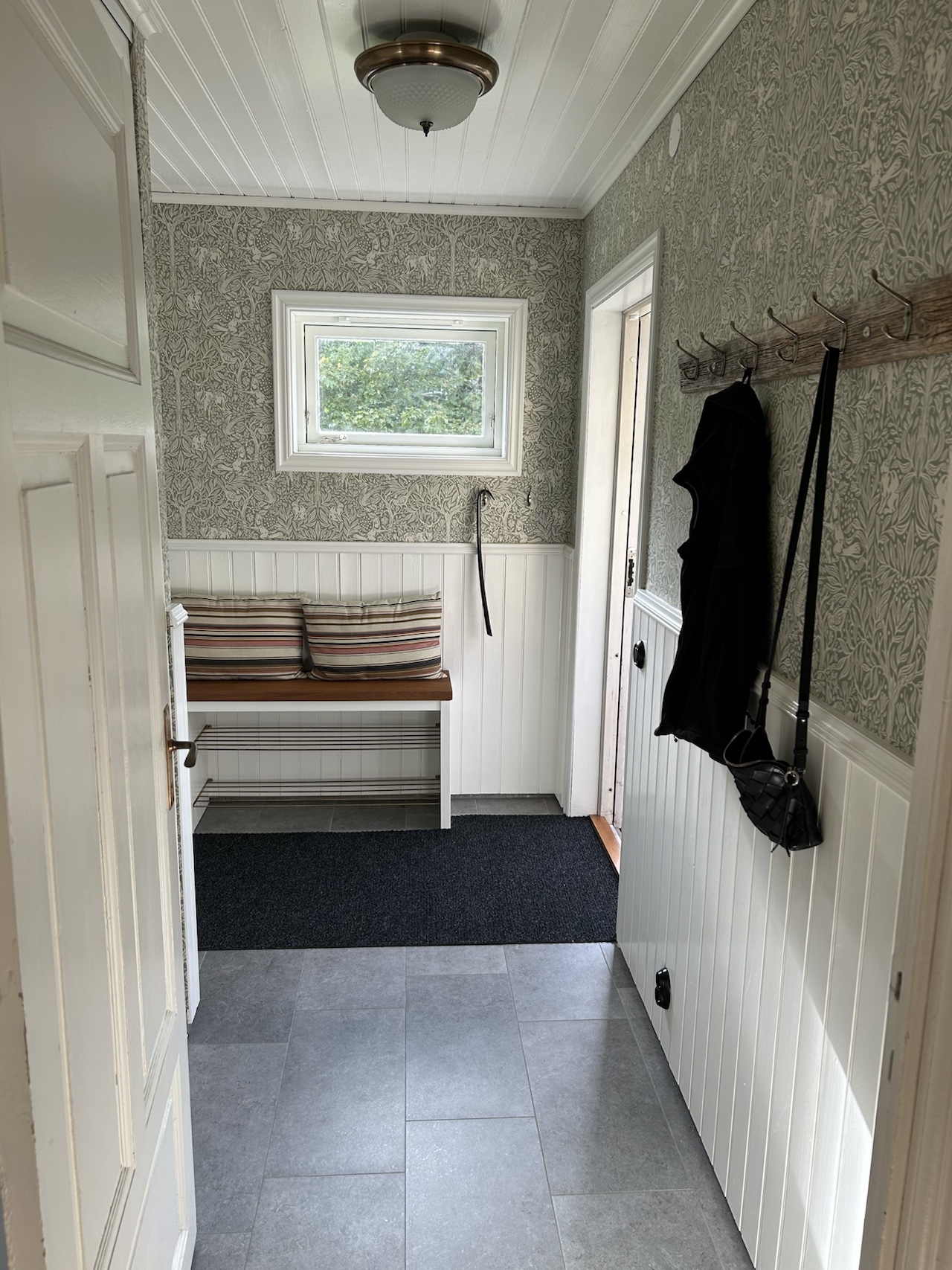 Entrance hallway with bench, hooks and a small window