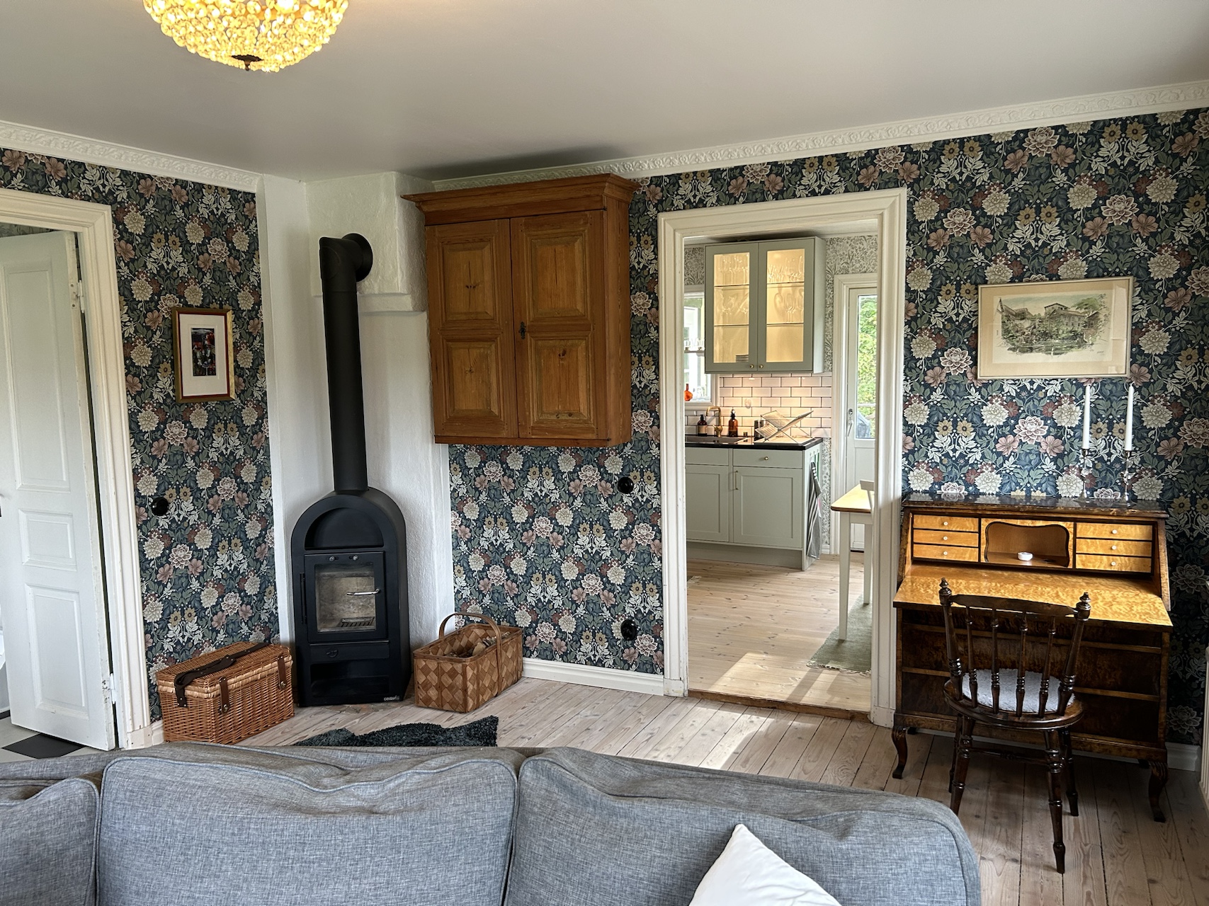 Living room showing the wood-burning stove and a dining table in the next room